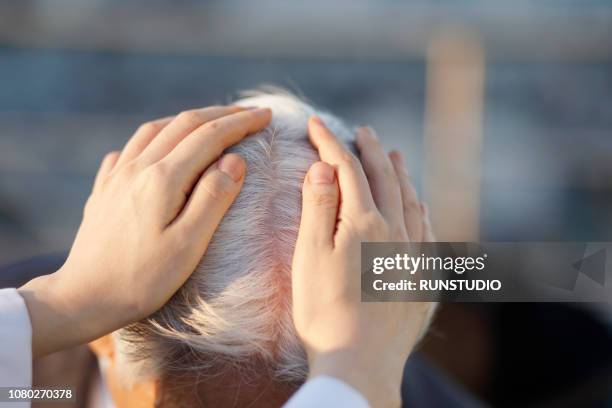 A dermatologist examining a patient's scalp