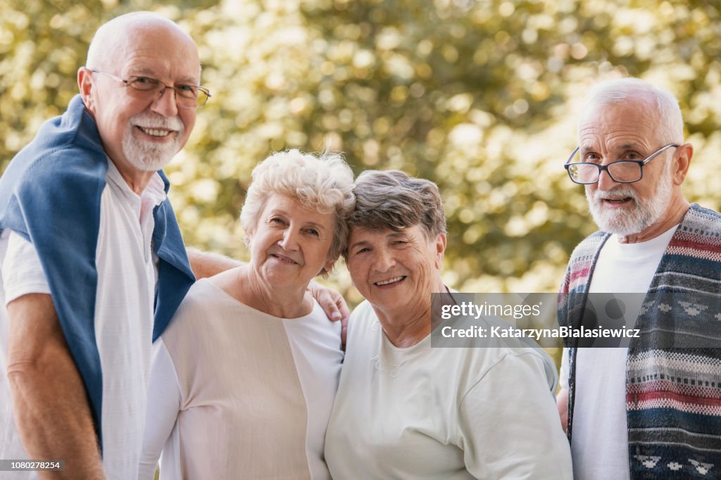 Group of senior friends smiling and having fun together at park