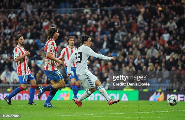 Mesut Ozil of Real Madrid scores their third goal during the Copa del Rey quarter final first leg match between Real Madrid and Atletico Madrid at...