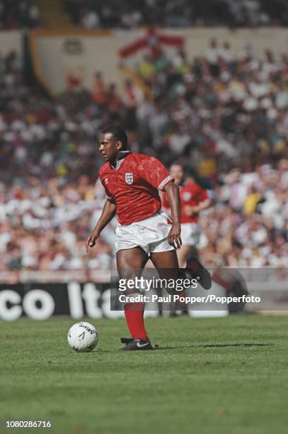 English professional footballer David Rocastle, midfielder with Arsenal, pictured with the ball during play between England and Brazil in an...