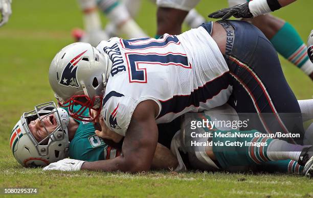 Ryan Tannehill of the Miami Dolphins screams out in pain as Adam Butler of the New England Patriots sacks him during the second quarter of the NFL...