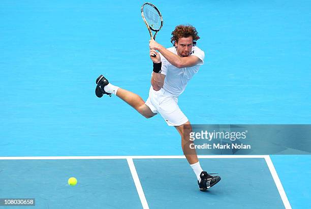 Ernests Gulbis of Lativa hits a backhand in his semi final match aginst Gilles Simon of France during day six of the 2011 Medibank International at...