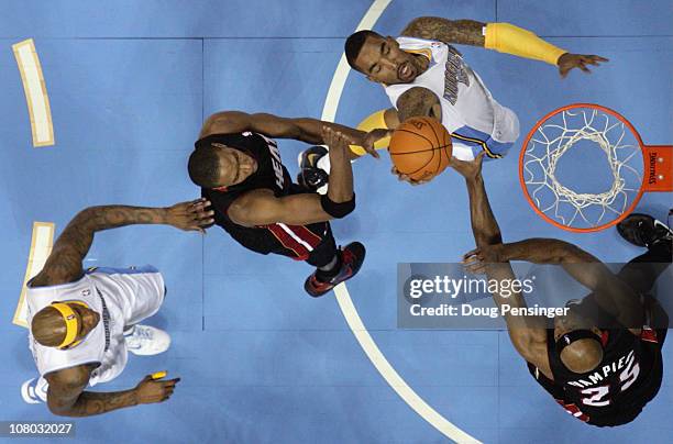 Smith of the Denver Nuggets puts up a shot between Chris Bosh and Eric Dampier of the Miami Heat as Al Harrington of the Nuggets follows the play at...