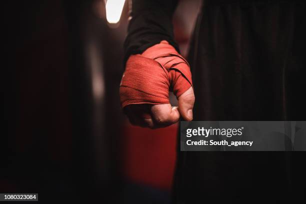 mano de hombre envuelto en vendajes de boxeo - combat sport fotografías e imágenes de stock