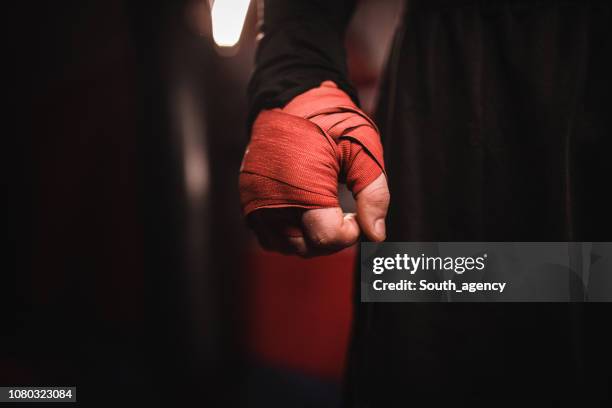 main de l’homme enveloppé dans des bandages de boxe - fighting ring stock photos et images de collection