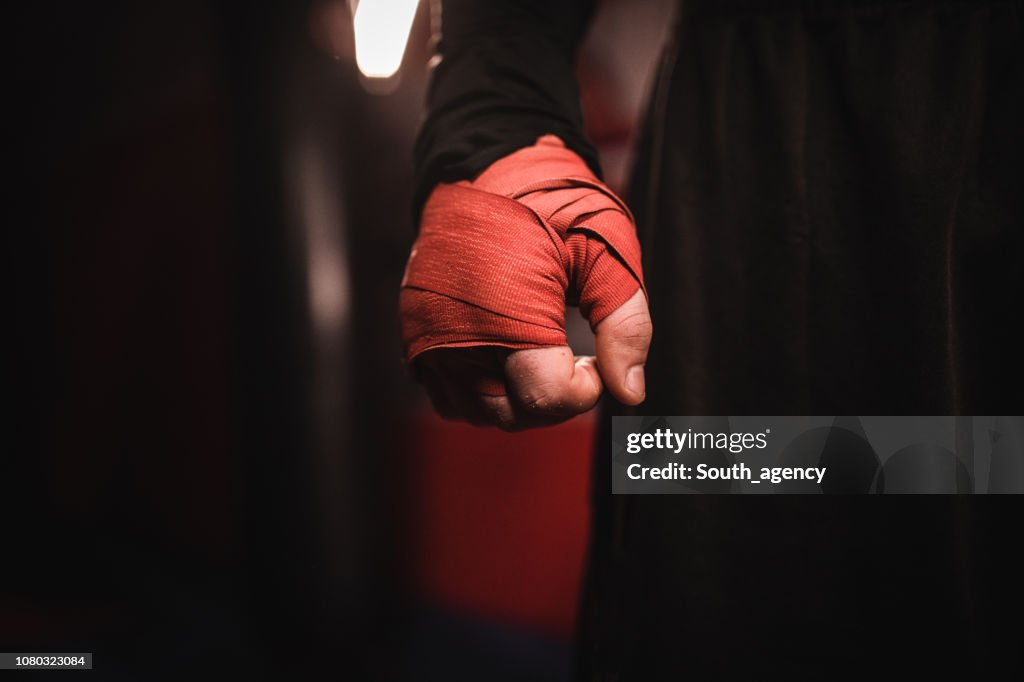 Mão de homem, envolvida em bandagens de boxe