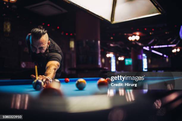 hombre barbudo jugando billar en un bar - billiard ball model fotografías e imágenes de stock
