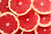 Close-up Grapefruit slices abstract background in Living Coral color.