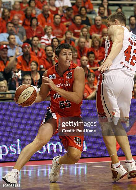 Damian Martin of the Wildcats drives around David Gruber of the Hawks contest the ball during the round 14 NBL match between the Perth Wildcats and...