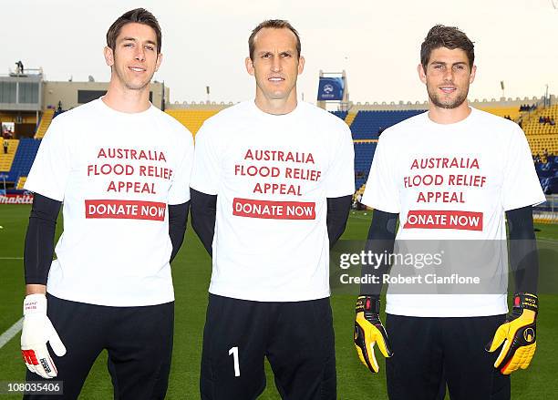 Australian goalkeepers Brad Jones, Mark Schwarzer and Nathan Coe poes with t-shirts which show their support for flood victims in Queensland,...