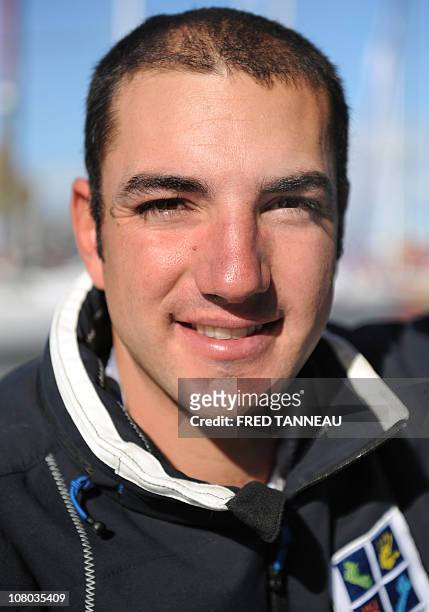 French skipper Damien Seguin poses on his monohull "Des pieds et des mains" on October 25, 2010 in Saint Malo harbour, western France, before the 9th...