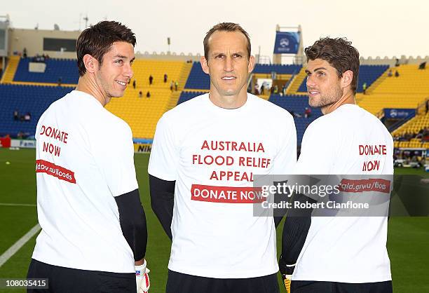 Australian goalkeepers Brad Jones, Mark Schwarzer and Nathan Coe poes with t-shirts which show their support for flood victims in Queensland,...