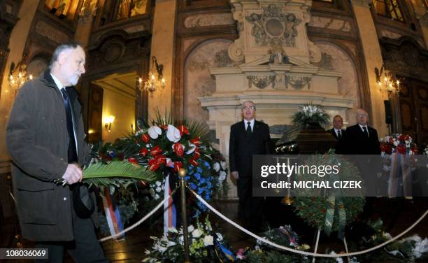 Man places flowers next to the coffin containing the remains of former Czech Czech senator and former Czech Foreign Minister Jiri Dienstbier on...