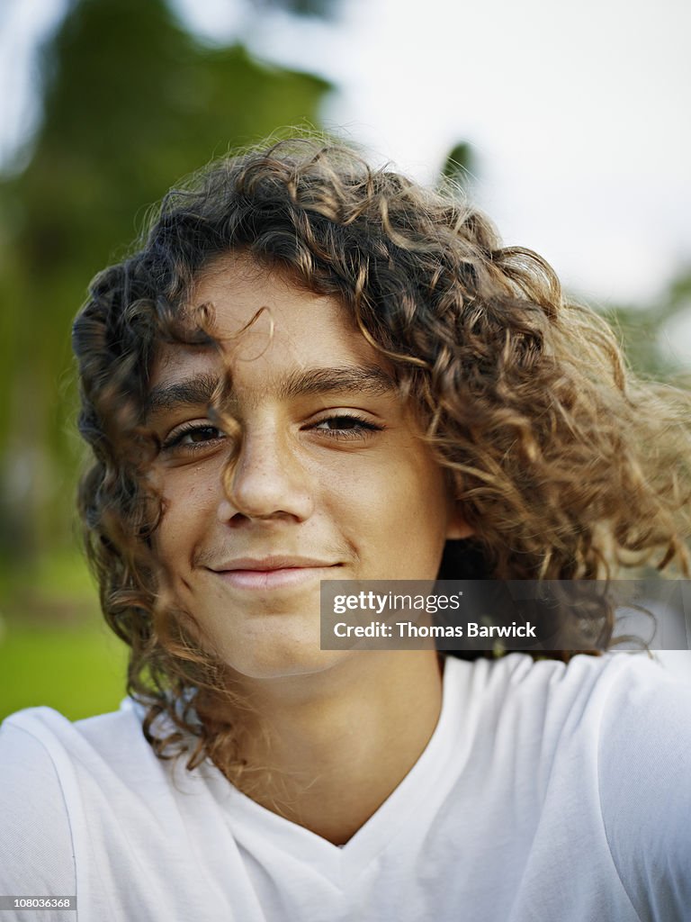 Teenage boy smiling with hair blowing in wind