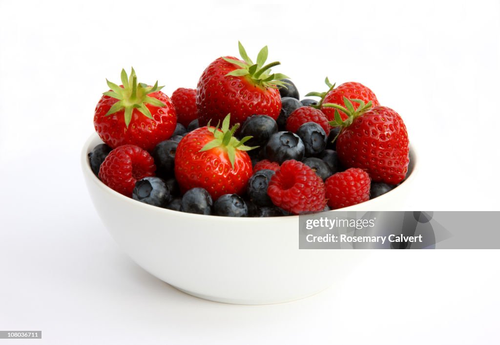 Freshly picked berries in white bowl.