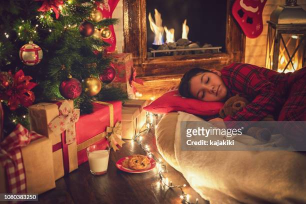 little girl in pajama fell asleep near tree on christmas eve - kid waiting stock pictures, royalty-free photos & images