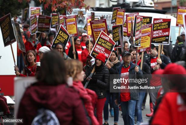 Kaiser Permanente mental health workers carry signs as they march in front of Kaiser Permanente San Francisco Medical Center on December 10, 2018 in...