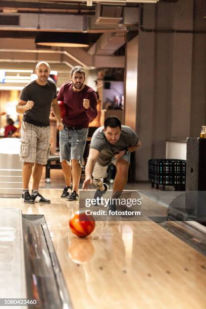 men cheering for their bowling team member - bowling for buddies stock pictures, royalty-free photos & images