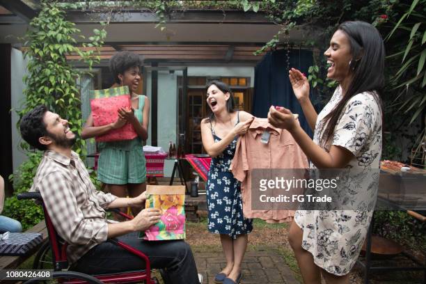 vrienden uit te wisselen presenteert op samenzijn barbecue feest - exchanging stockfoto's en -beelden