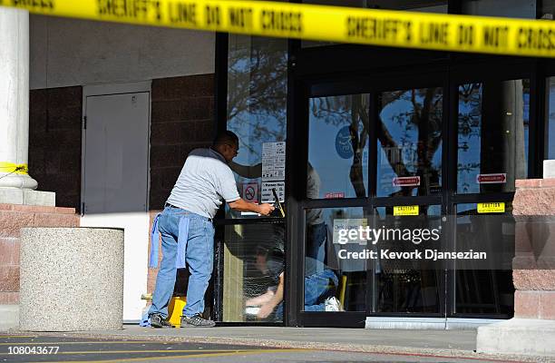 Workers clean the Safeway supermarket, the site of the shooting rampage in the La Toscana Village parking lot, as they prepare for re-opening on...