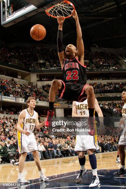 Taj Gibson of the Chicago Bulls dunks against Mike Dunleavy and Josh McRoberts of the Indiana Pacers on January 14, 2011 at Conseco Fieldhouse in...