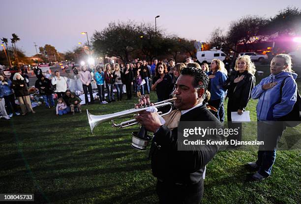 Mariachi Ruben Moreno plays the national anthem for visitors at a makeshift memorial that continues to grow in front of University Medical Center for...