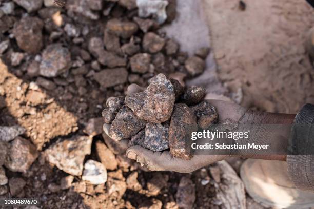 Miner collects small chunks of cobalt inside the CDM Kasulo mine. "n"nCobalt is a vital mineral needed for the production of rechargeable batteries....