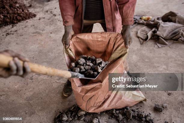 Miner fills a bag with cobalt at the CDM Kasulo mine. "n"nCobalt is a vital mineral needed for the production of rechargeable batteries. Two thirds...