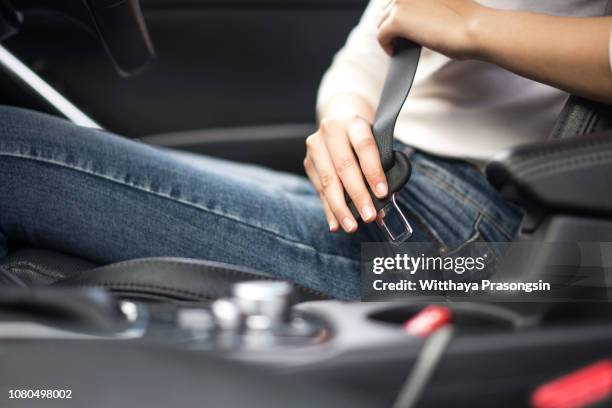 passenger woman fastening seat belt in the car, safety concept - cinturón de seguridad fotografías e imágenes de stock