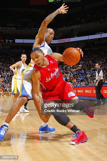 Eric Gordon of the Los Angeles Clippers slashes to the hoop against Monta Ellis of the Golden State Warriors on January 14, 2011 at Oracle Arena in...