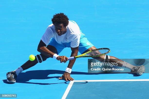 Gael Monfils of France stretches to play a forehand during his match against Lleyton Hewitt of Australia during day four of the AAMI Classic at...