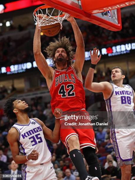 Robin Lopez of the Chicago Bulls dunks between Marvin Bagley III and Nemanja Bjelica of the Sacramento Kings at the United Center on December 10,...