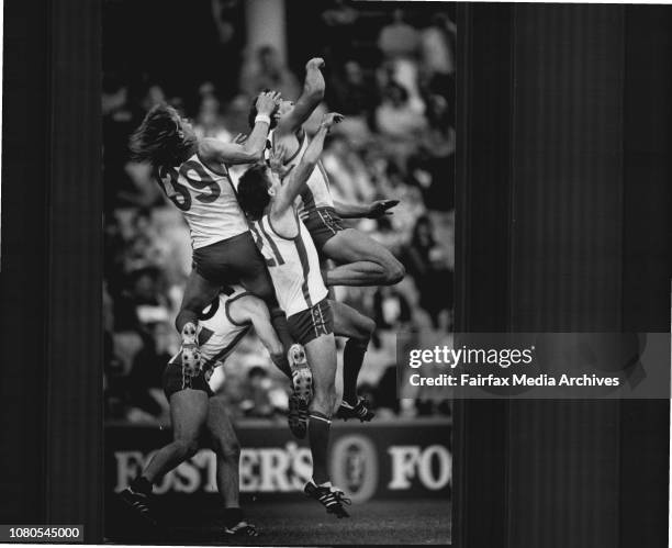 Warwick Capper going up for a mark behind Norths' Darren Crocker and team-mate Tony Morwood. May 31, 1987. .