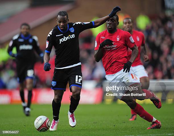 John Utaka of Portsmouth breaks away from Guy Moussi of Nottingham Forest during the npower Championship match between Nottingham Forest and...