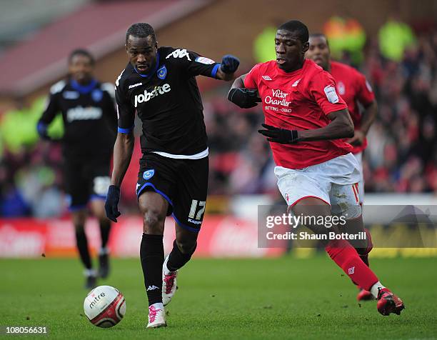 John Utaka of Portsmouth breaks away from Guy Moussi of Nottingham Forest during the npower Championship match between Nottingham Forest and...
