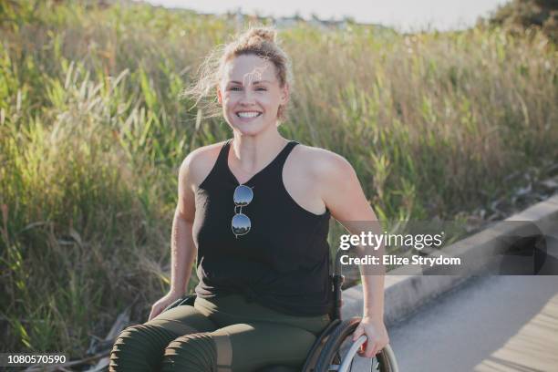 paraplegic woman in her wheelchair - junge frau im rollstuhl stock-fotos und bilder