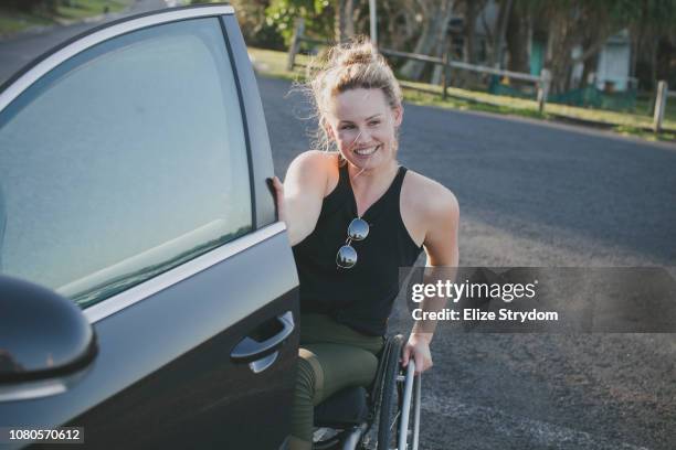 a paraplegic woman by a car - paraplegic woman photos et images de collection