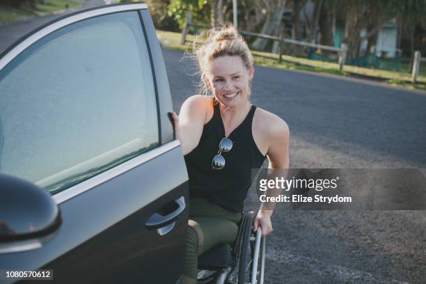A paraplegic woman by a car