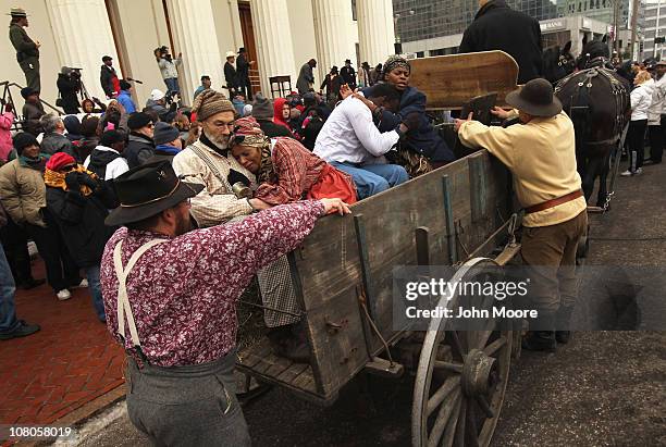 People portraying slaves prepare to be carted off during a re-enactment of a mid-19th century slave auction January 15, 2011 in downtown St. Louis,...