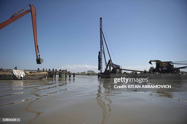 Workers repair a breach at Dique Canal dike, in Calamar, Bolivar department, northern Colombia, on January 13, 2011. A month ago the Dique canal...