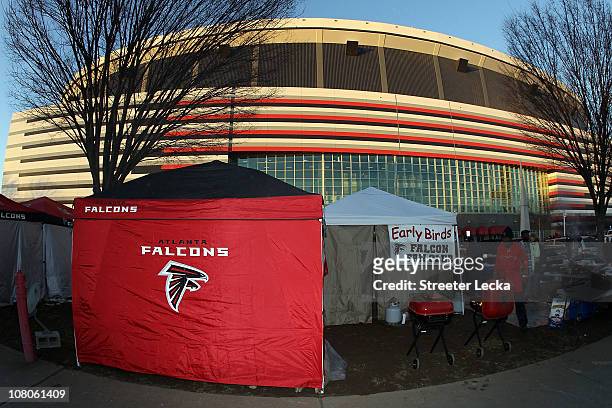 Fan of the Atlanta Falcons cooks on the grill as he tailgates outside the stadium prior to the Falcons playing against the Green Bay Packers during...