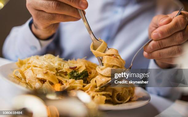 cerca de pasta irreconocible hombre comer para el almuerzo. - pasta fotografías e imágenes de stock