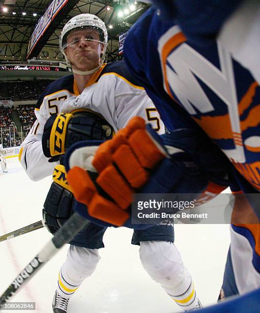 Tyler Myers of the Buffalo Sabres moves in to hit a New York Islander at the Nassau Coliseum on January 15, 2011 in Uniondale, New York.