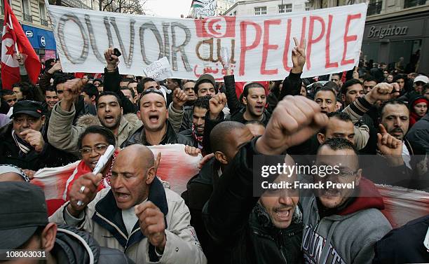 Tunisian expatriates shout slogans while holding a banner reading "People Power" as they demonstrate on January 15, 2011 in Paris, France. Zine...