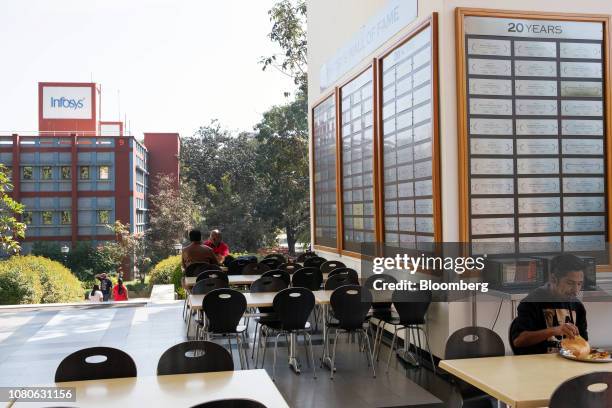 Employees sit at tables in a canteen area at the Infosys Ltd. Campus in the Electronics City information technology hub in Bengaluru, India, on...