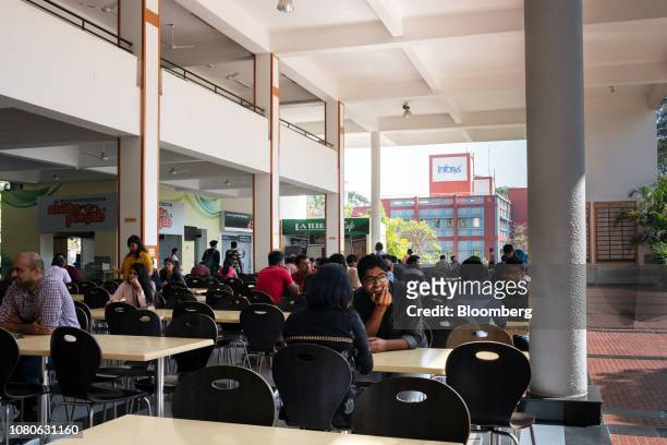 Employees sit at tables in a canteen area at the Infosys Ltd. Campus in the Electronics City information technology hub in Bengaluru, India, on...