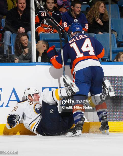 Thomas Vanek of the Buffalo Sabres is knocked to the ice by Trevor Gillies of the New York Islanders on January 15, 2011 at Nassau Coliseum in...