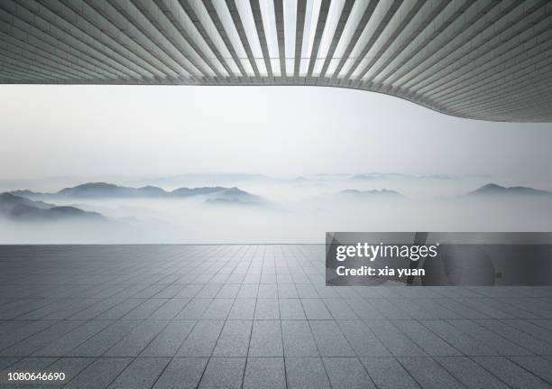 empty pavement with misty mountains - futuristic landscape stock pictures, royalty-free photos & images