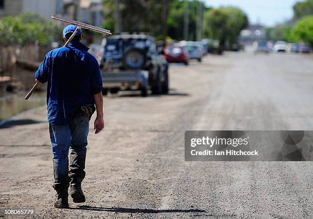 Volunteer walks down a road offering his services to whomever needs help on January 16, 2011 in Rockhampton, Australia. Rockampton experienced some...