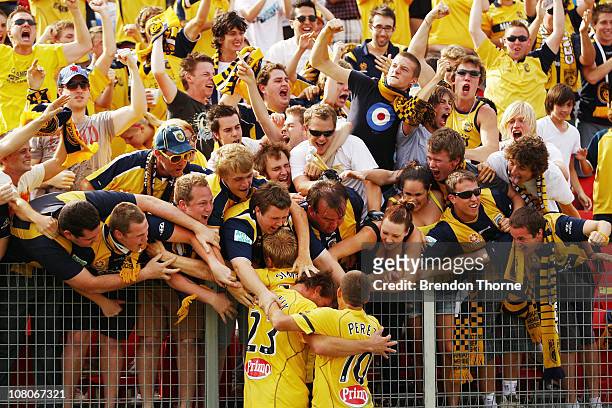 Matt Simon of the Mariners celebrates with team mates and fans after scoring against the Jets during the round 23 A-League match between the...